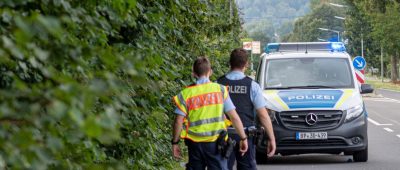 Polizisten gehen in Engelskirchen an einer Straße in der Nähe einer Bahnstrecke entlang