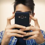 Junge mit Smartphone in der Hand -Teenager mit Handy