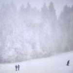 Winterberg_ Zwei Spaziergänger und ein Snowboarder sind auf der künstlich beschneiten Piste am Poppenberg unterwegs. Das Skigebiet ist mit zwei Liften in die Saison gestartet